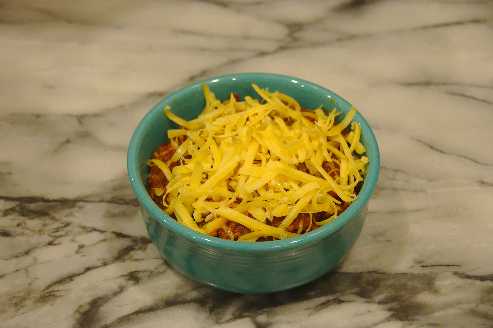 Grated cheddar over chili